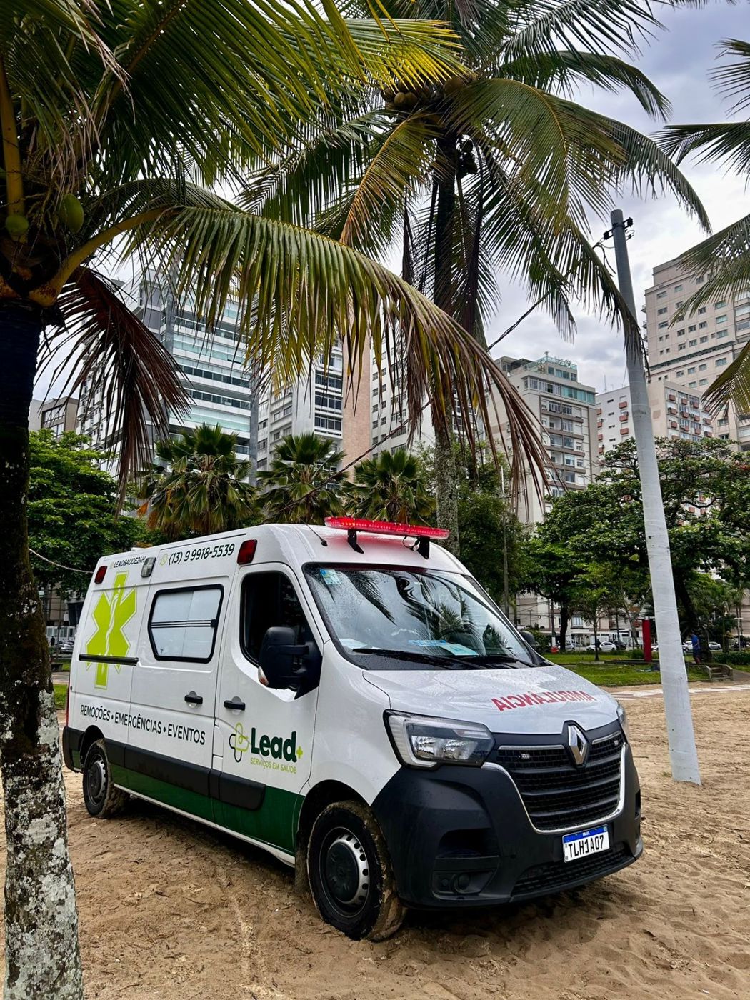 Ambulância da LEAD entre coqueiros na orla de Santos